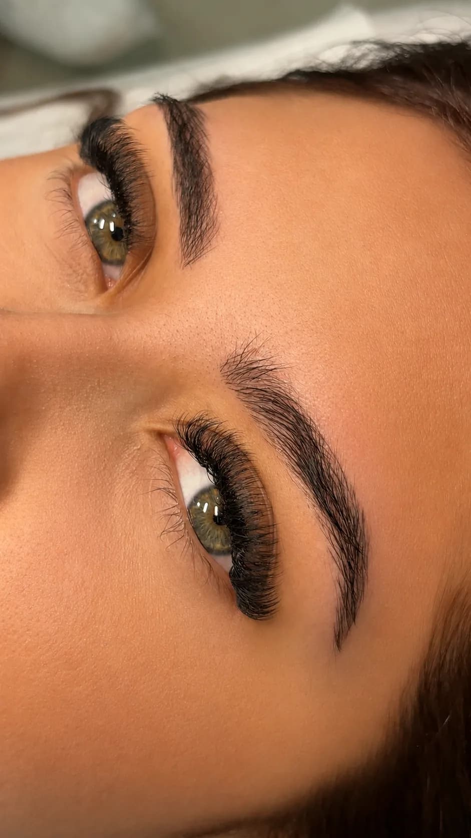 Cejas con trazos pelo a pelo finos que siguen la dirección del vello natural, con la mirada abierta y la forma sin contorno marcado.