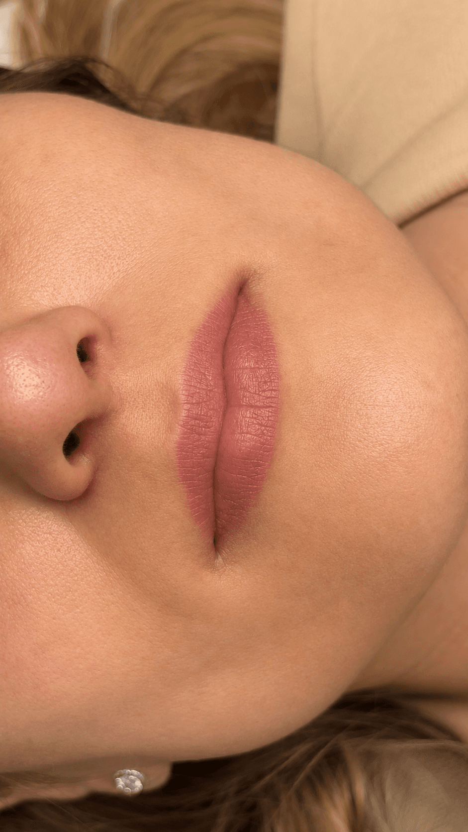 Labio con color aplicado, tono rosado suave y acabado mate, en vista de tres cuartos.