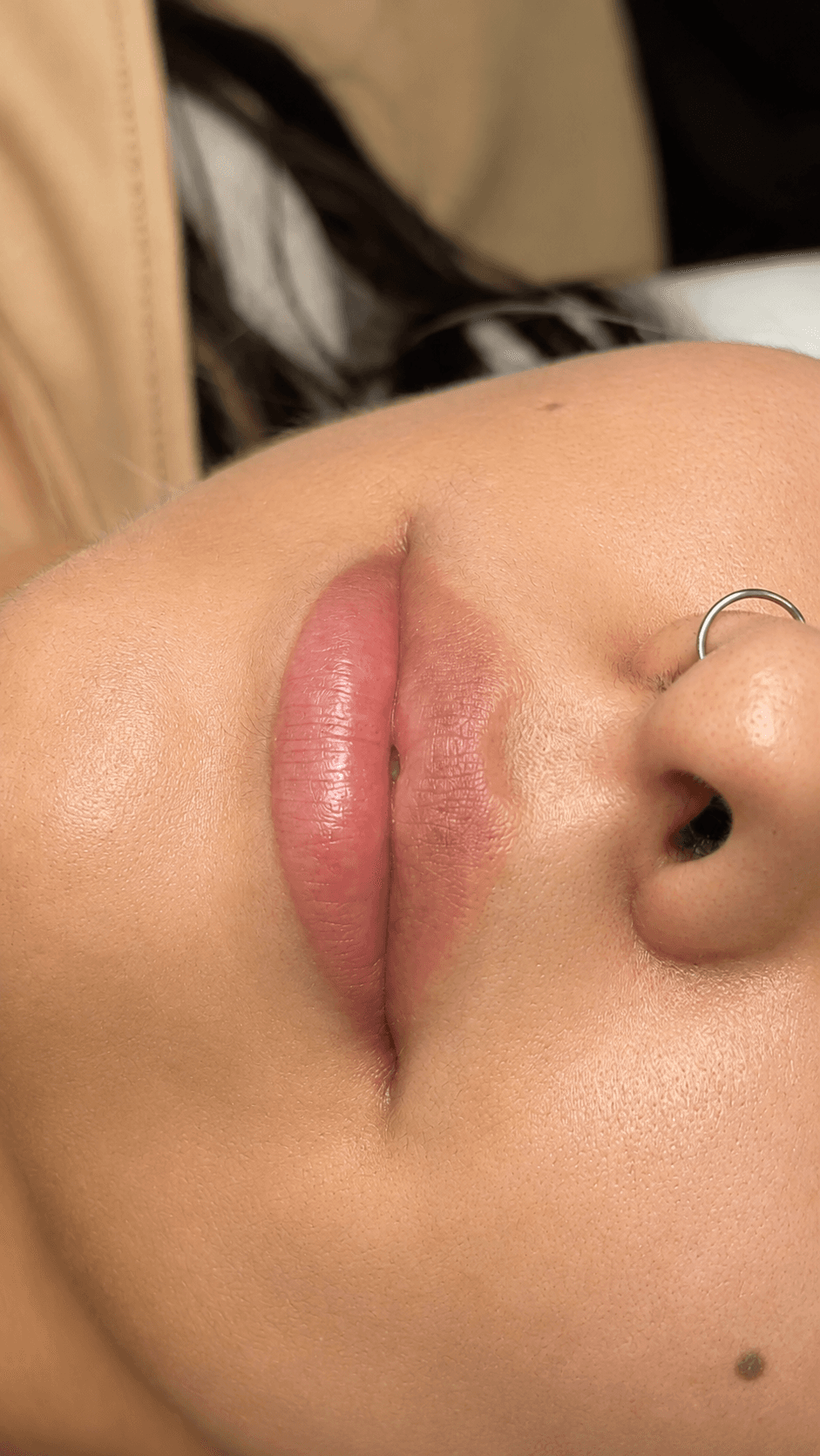 Labio con color aplicado, tono rosado suave, en vista de tres cuartos.