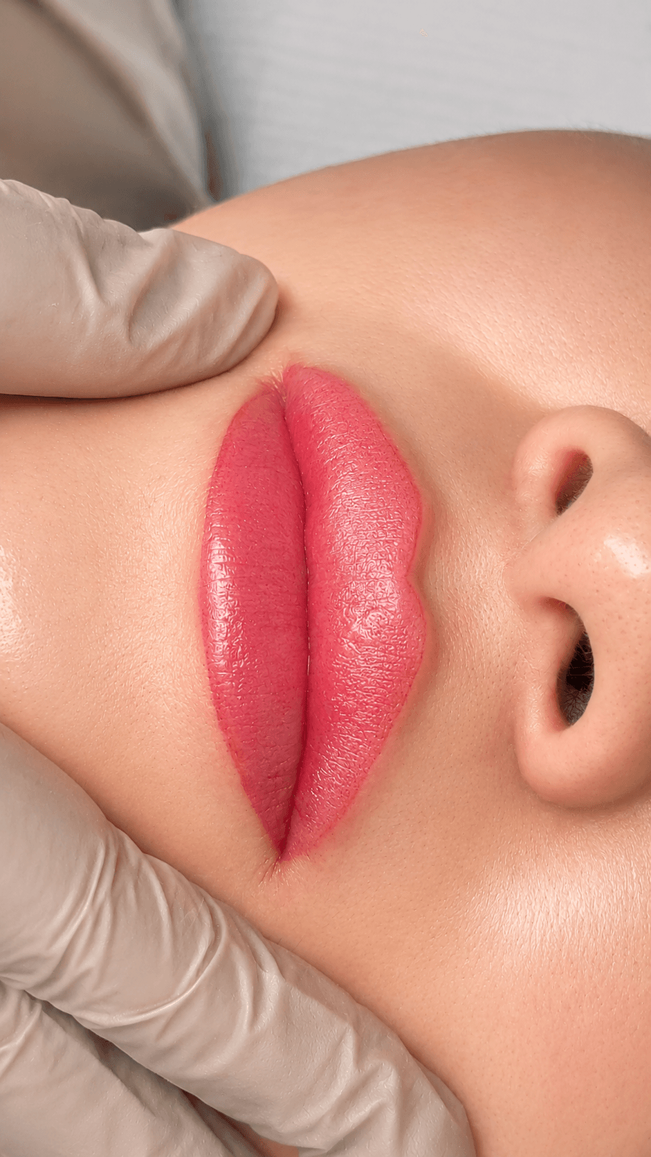 Labio con color más definido e intenso, mismo encuadre con la mano enguantada apoyada sobre la frente.