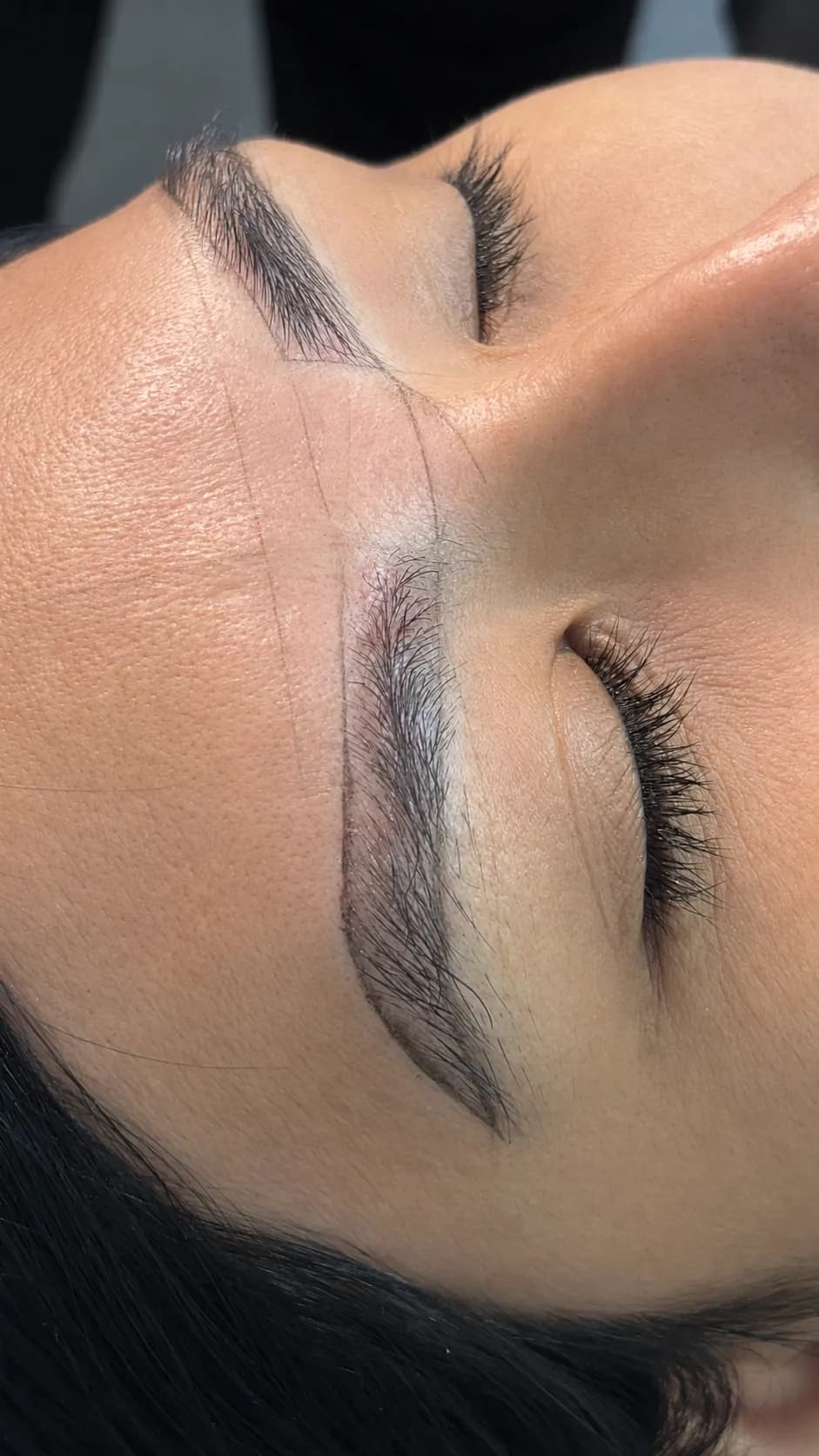 Ceja con el mapa de diseño marcado sobre la piel y el trazo pelo a pelo recién aplicado en la cabeza.